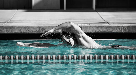 Swimmer doing a single-arm freestyle drill with a kickboard and center-mount snorkel