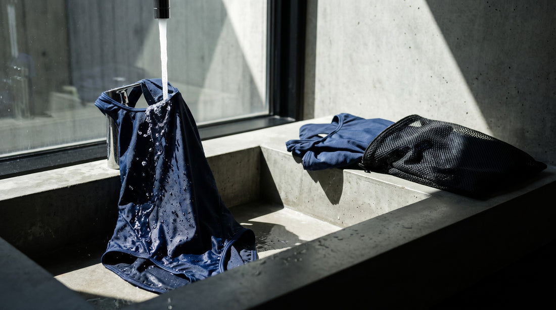 Training swimsuit being rinsed in fresh water beside a mesh drying bag