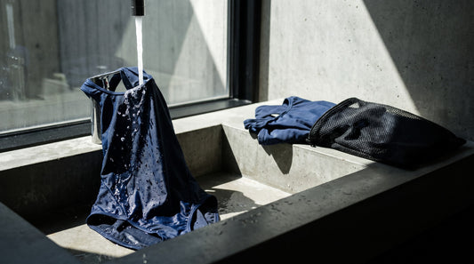 Training swimsuit being rinsed in fresh water beside a mesh drying bag