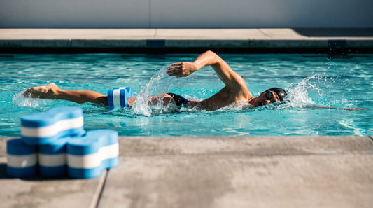 Swimmer pulling freestyle with a foam pull buoy between the thighs