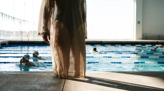 Swimmer on the pool deck wearing a mesh drag suit over a training swimsuit