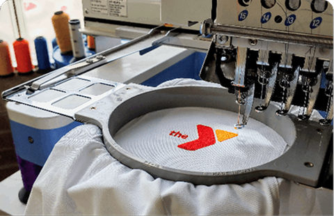 Embroidery machine with a colorful logo on a piece of fabric
