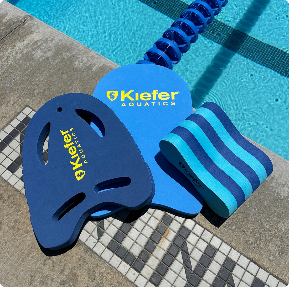 Kiefer Aquatics swim training tools on a poolside surface