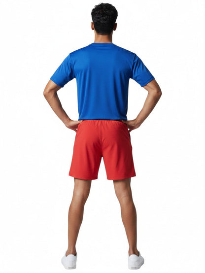 A male lifeguard wearing Kiefer blue short sleeve crew neck rashguard and red shorts from behind.