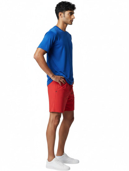 Male model wearing Kiefer blue short sleeve crew neck rashguard and red shorts in profile view