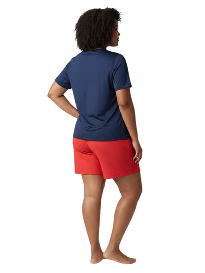 A model wearing Kiefer navy blue short sleeve crew neck rashguard and red shorts, back view.