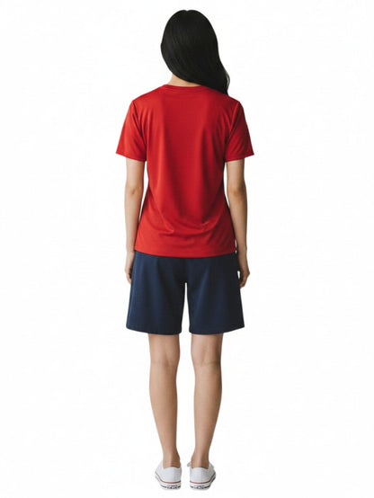 Back view of a woman wearing a red Kiefer short sleeve crew neck rashguard with navy blue shorts