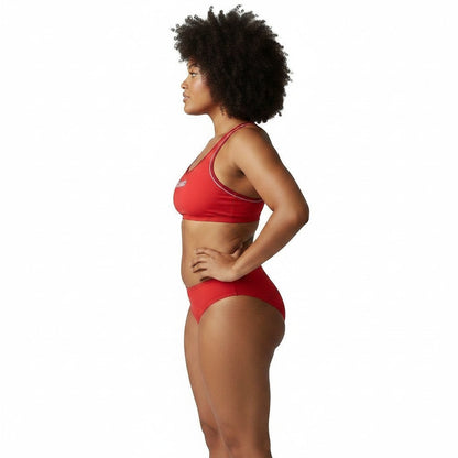 Model wearing Kiefer red reversible racer back guard top and matching bikini bottoms, side view.