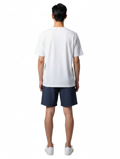 Back view of a man wearing Kiefer white short sleeve crew neck rashguard with navy blue shorts